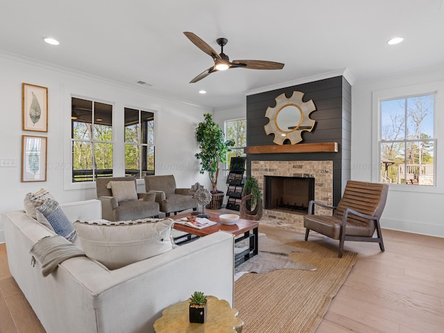 living room featuring a wealth of natural light, light hardwood / wood-style flooring, and crown molding