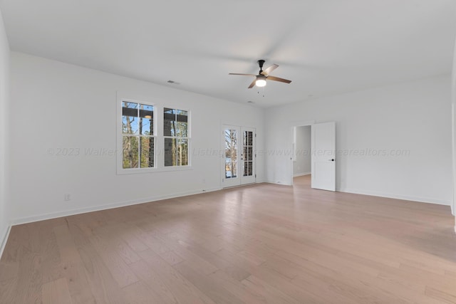 spare room featuring french doors, light wood-type flooring, and ceiling fan