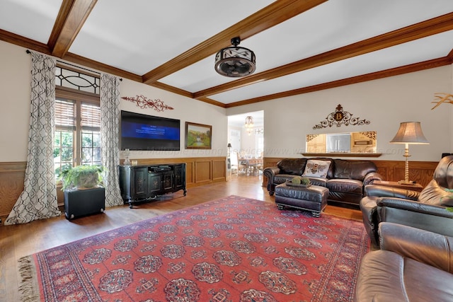 living room featuring beamed ceiling, crown molding, wooden walls, and light hardwood / wood-style flooring