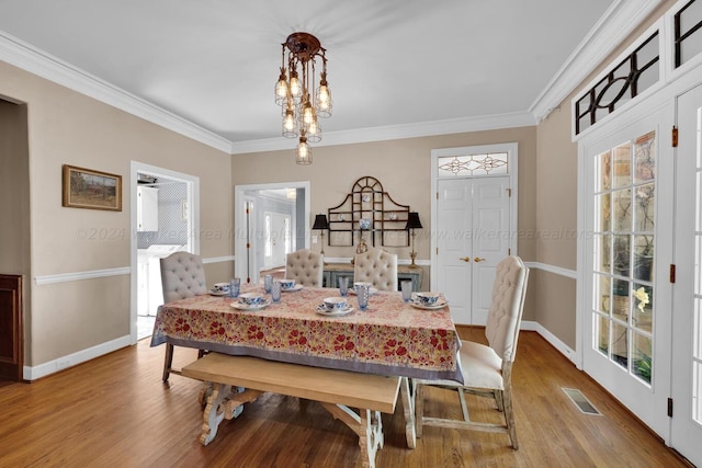 dining area with hardwood / wood-style floors and ornamental molding