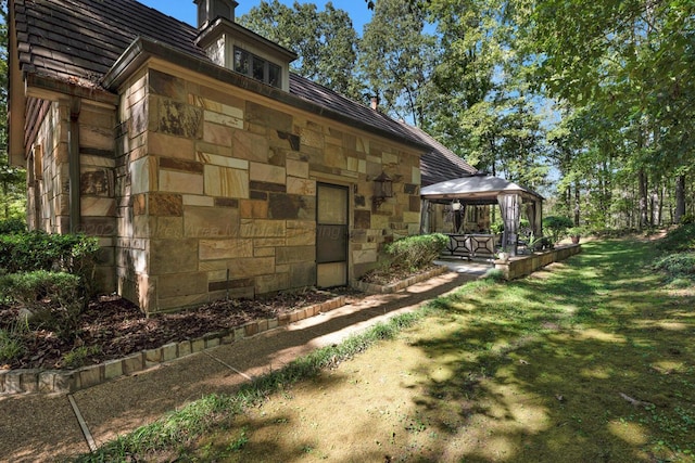 view of property exterior with a gazebo and a yard