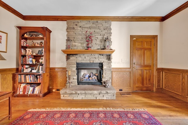 unfurnished living room with a fireplace, crown molding, and light hardwood / wood-style flooring