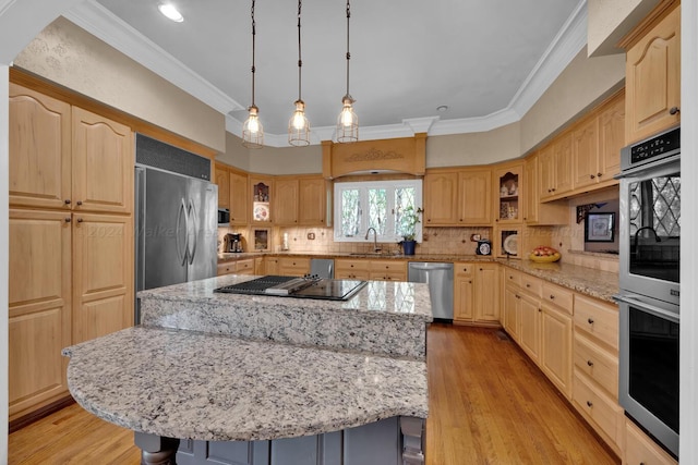 kitchen featuring light stone countertops, light hardwood / wood-style flooring, a kitchen island, and appliances with stainless steel finishes