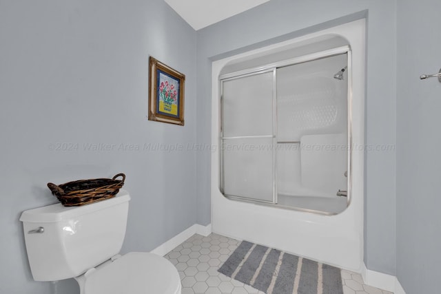 bathroom with combined bath / shower with glass door and toilet