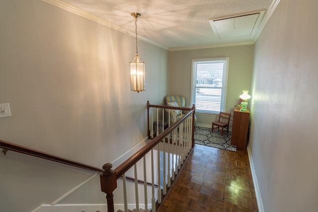 stairway featuring attic access, ornamental molding, a textured ceiling, and baseboards