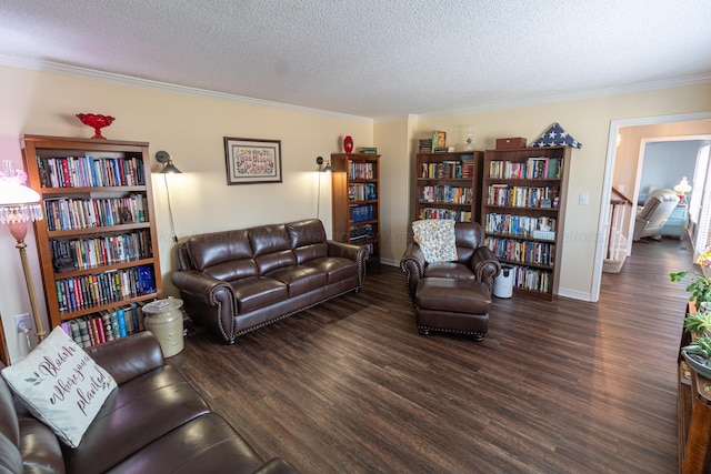 living room featuring a textured ceiling, ornamental molding, wood finished floors, and baseboards