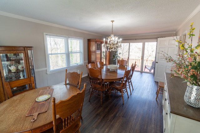 dining area with a textured ceiling, dark wood-type flooring, an inviting chandelier, and crown molding