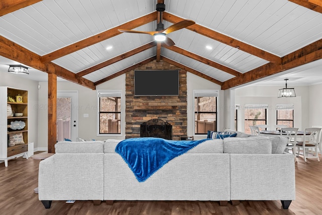 living room with lofted ceiling with beams, wood finished floors, a wealth of natural light, and a large fireplace