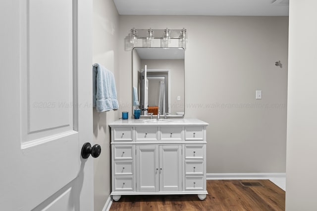 bathroom featuring vanity, baseboards, and wood finished floors