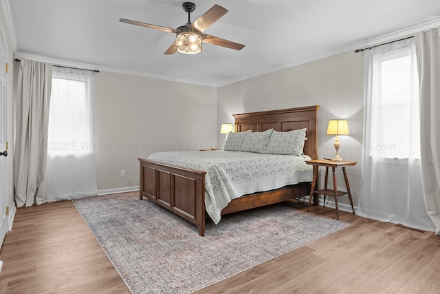 bedroom featuring baseboards, a ceiling fan, crown molding, and light wood-style floors