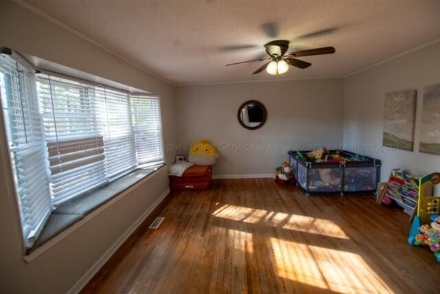 bedroom with hardwood / wood-style flooring, ceiling fan, and ornamental molding