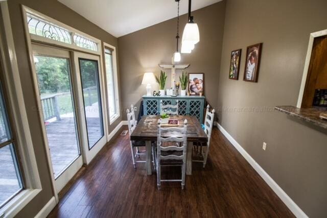 dining room with dark wood-type flooring and vaulted ceiling