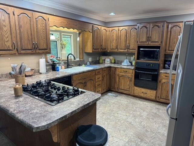 kitchen with black appliances, kitchen peninsula, sink, and ornamental molding