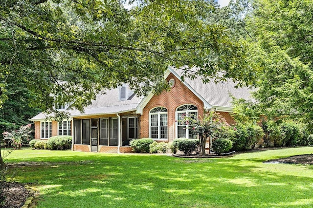 view of front facade featuring a sunroom and a front yard