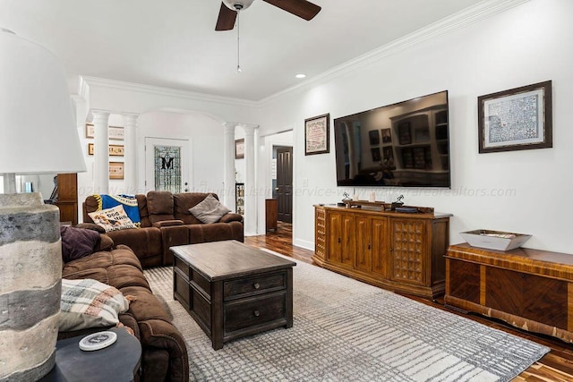 living room featuring light hardwood / wood-style flooring, ceiling fan, ornamental molding, and ornate columns