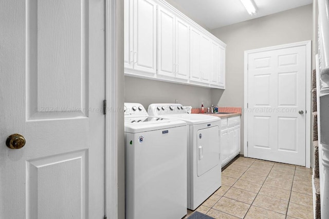 laundry room featuring light tile patterned flooring, cabinets, separate washer and dryer, and sink