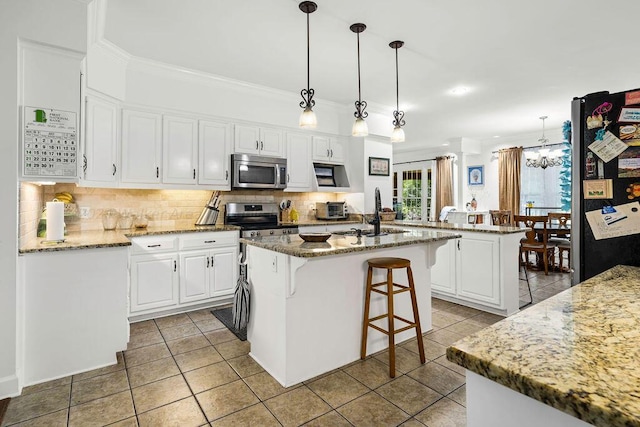 kitchen featuring white cabinets, appliances with stainless steel finishes, and a center island with sink