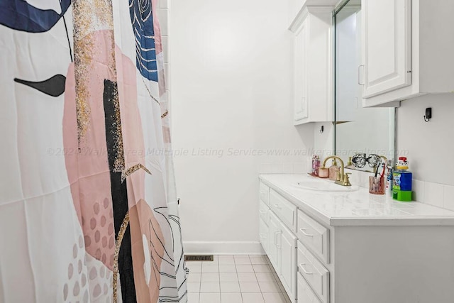 bathroom with tile patterned flooring, vanity, and walk in shower