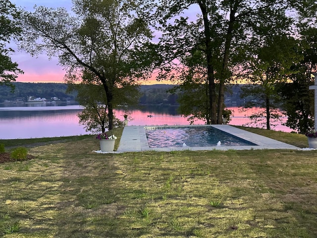 exterior space featuring a lawn and a water view