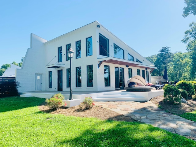 rear view of house with a lawn and stucco siding