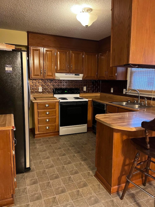 kitchen with dishwasher, a breakfast bar, stainless steel fridge, sink, and electric range oven