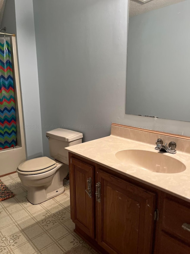 full bathroom featuring toilet, a textured ceiling, shower / bath combo with shower curtain, and vanity