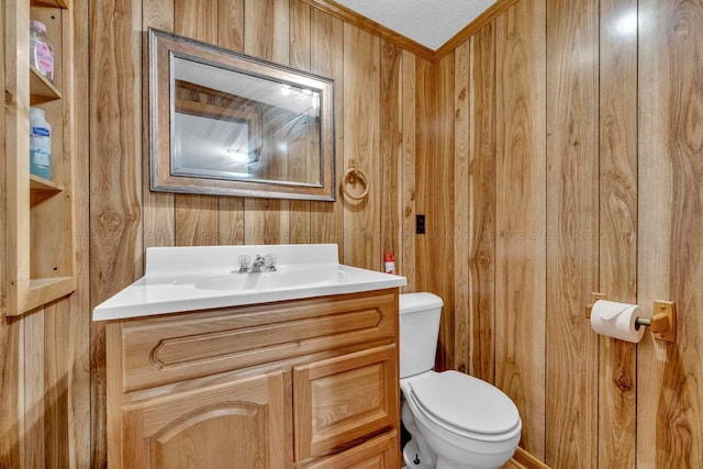 bathroom with vanity, a textured ceiling, toilet, and wood walls