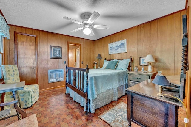 bedroom with a textured ceiling, ceiling fan, and wood walls