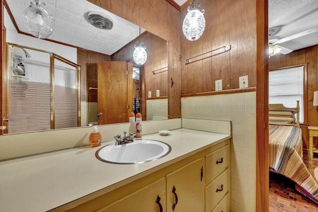 bathroom with vanity, wood walls, plenty of natural light, and crown molding