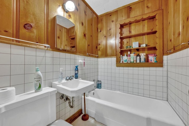 bathroom with sink, a washtub, toilet, tile walls, and tasteful backsplash