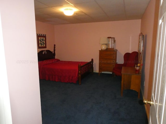 bedroom featuring a paneled ceiling and dark colored carpet