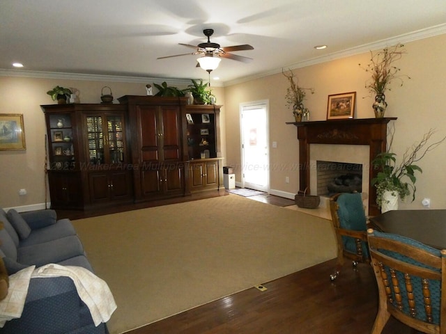 living room with ceiling fan, ornamental molding, and dark hardwood / wood-style floors