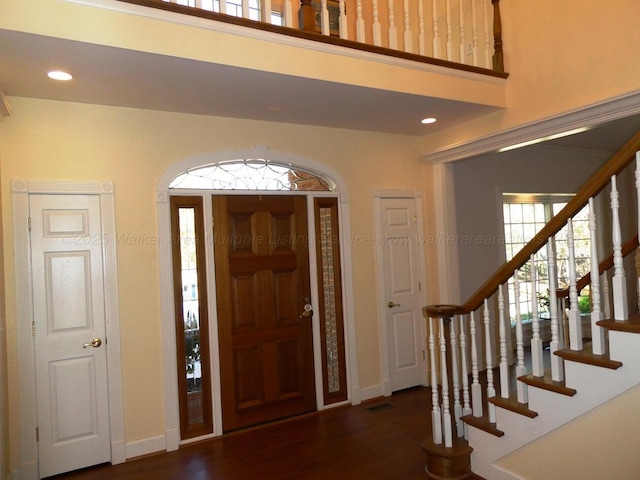 entrance foyer with dark wood-type flooring and a high ceiling