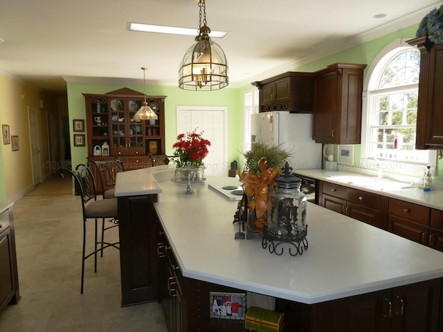 kitchen featuring a kitchen island, white fridge with ice dispenser, and pendant lighting