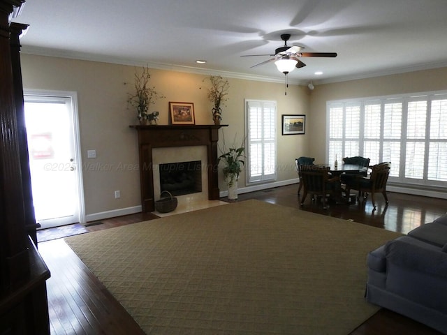 living room with dark hardwood / wood-style flooring, ornamental molding, and ceiling fan