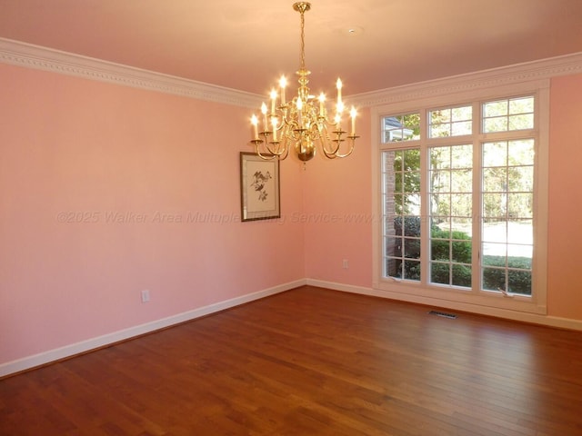 empty room featuring crown molding, hardwood / wood-style floors, and a chandelier