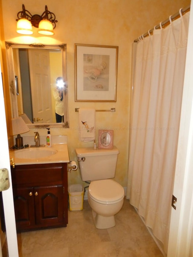 bathroom with vanity, toilet, and walk in shower