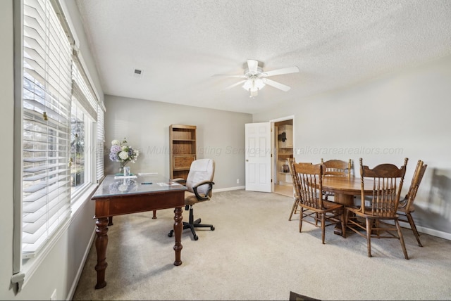 carpeted office featuring ceiling fan and a textured ceiling