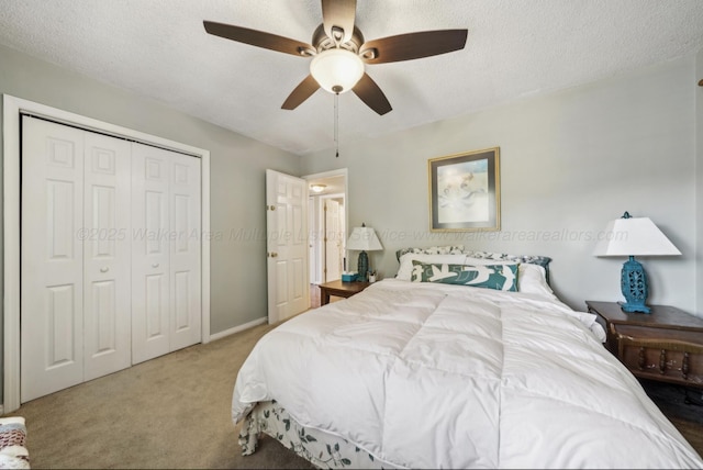 bedroom featuring ceiling fan, carpet flooring, a closet, and a textured ceiling