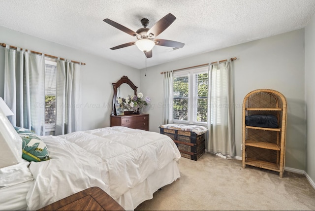 carpeted bedroom featuring a textured ceiling and ceiling fan