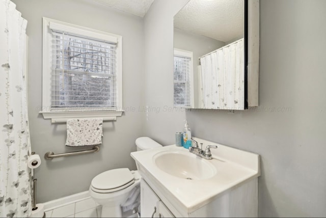 bathroom with tile patterned flooring, vanity, a textured ceiling, and toilet