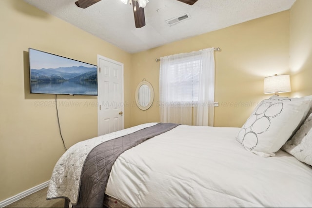 bedroom featuring ceiling fan, carpet, and a textured ceiling