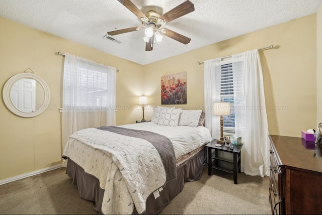 bedroom featuring light carpet, a textured ceiling, and ceiling fan