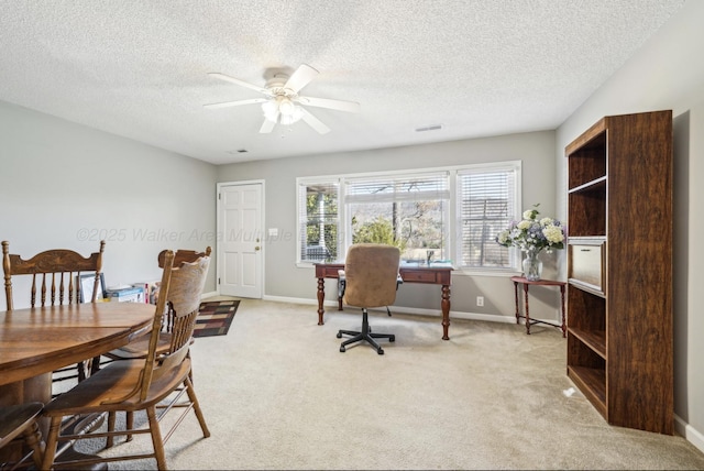 office space featuring ceiling fan, light colored carpet, and a textured ceiling