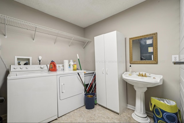 laundry area featuring a textured ceiling and washing machine and clothes dryer