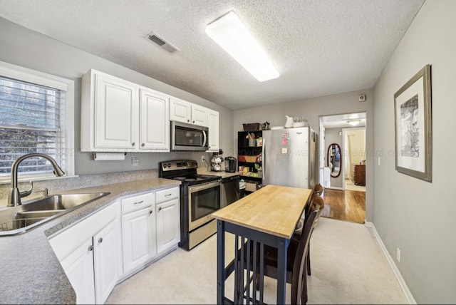 kitchen featuring white cabinetry, sink, a textured ceiling, and appliances with stainless steel finishes