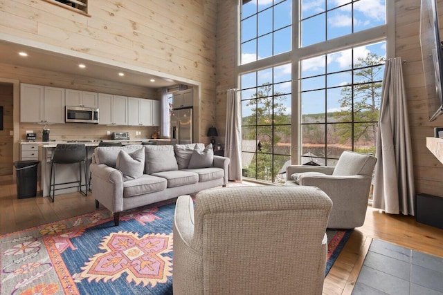 living room with hardwood / wood-style flooring, a wealth of natural light, and a towering ceiling