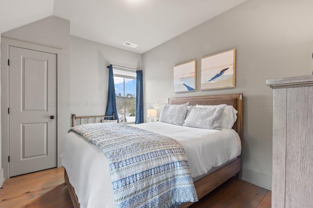 bedroom featuring dark hardwood / wood-style flooring and vaulted ceiling