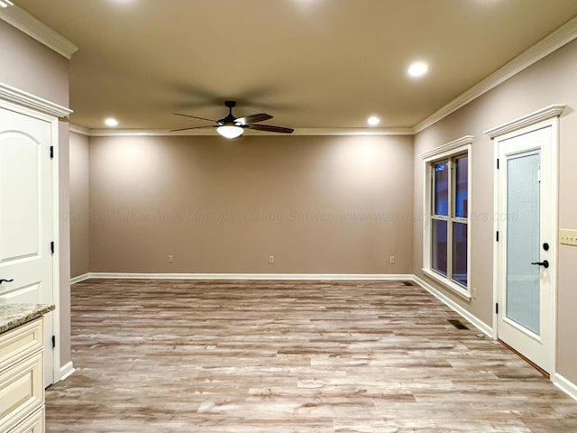 empty room with ceiling fan, light hardwood / wood-style floors, and crown molding