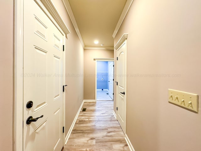 hall featuring ornamental molding and light hardwood / wood-style flooring